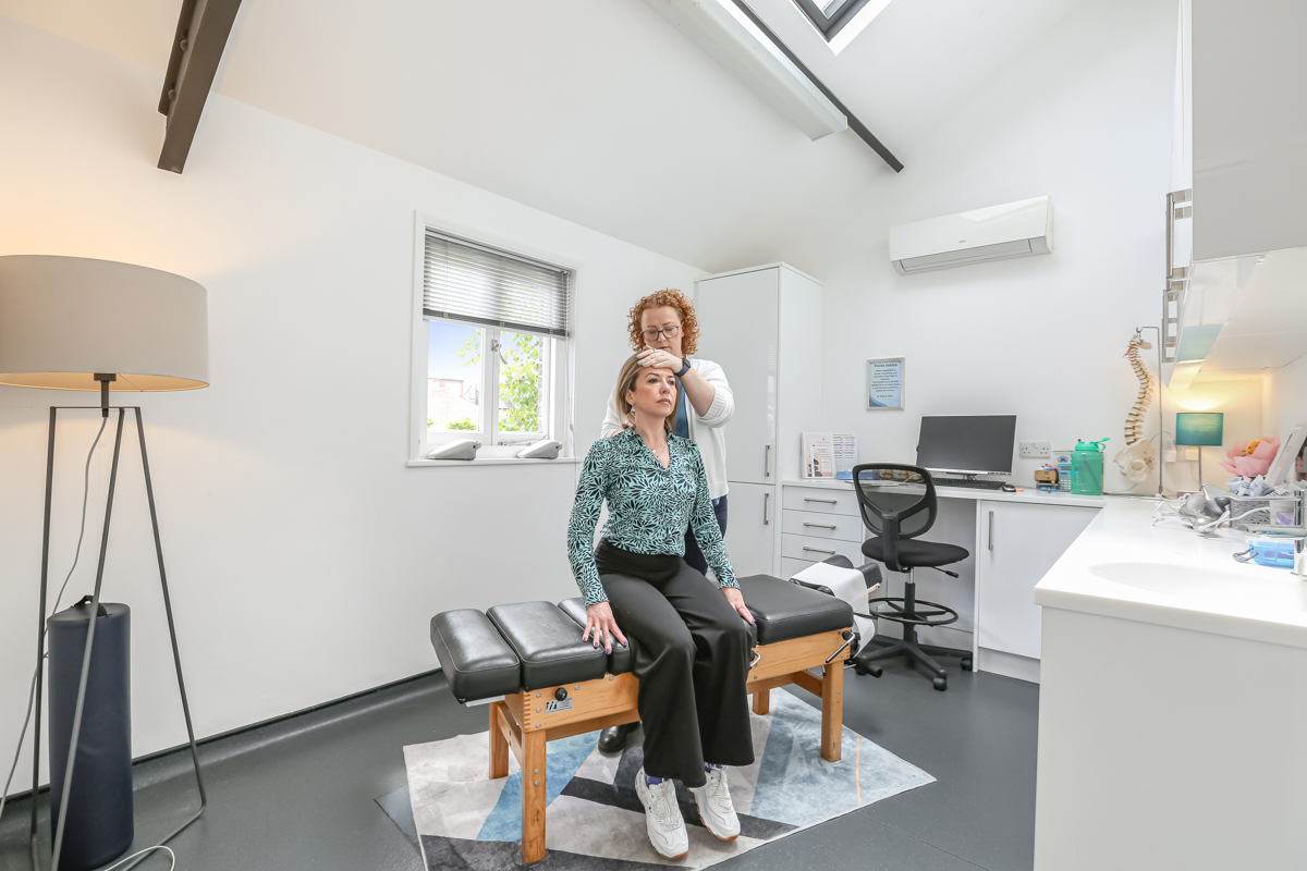 Dr Kelly performing a cervical assessment for headache treatment at Kingston Chiropractic